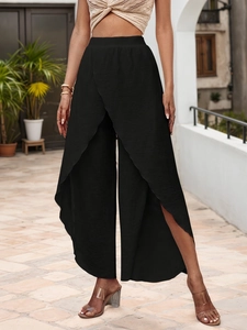Detail of high-waist black wide-leg beach pants featuring a flowy front slit design