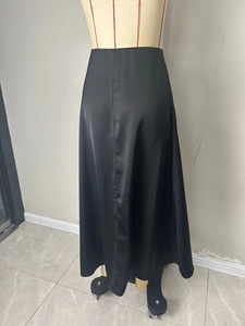 Detailopname van elegante zwarte satijnen maxi-rok met zijdeachtige textuur en hoge taille