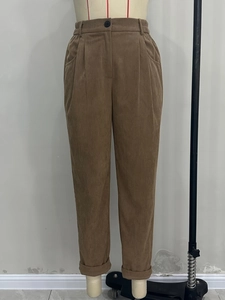 Detail of high waist corduroy trousers in brown with elastic waist and side pockets