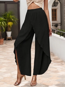 Detail of elegant black high-waisted wide-leg trousers with overlap split design