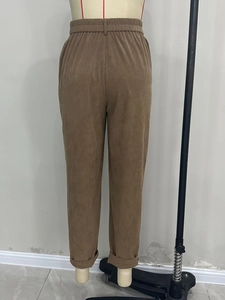 Detail view of high waist corduroy pants in brown with vertical ribbed texture