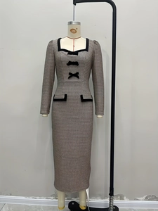 Detail of square neck knit dress with black bows and classic checkered pattern
