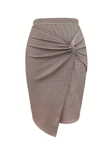 Detail of houndstooth plaid pencil skirt with front knot and asymmetrical wrap hem