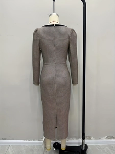 Detail of houndstooth knit dress featuring back zipper closure and slit hemline