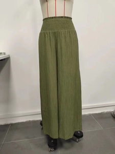 Detail of high waisted olive green wide leg pants with vertical pleated texture design