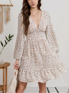 Detalle de vestido floral con escote en V, manga larga y dobladillo con volantes