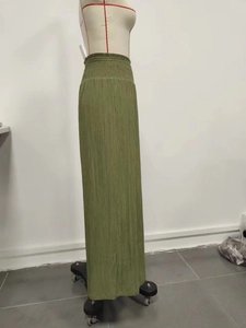 Detail of olive green wide leg trousers featuring a high smocked elastic waist and pleats