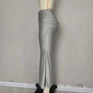 Détail d'une jupe froncée argentée avec une texture de tissu satiné métallique brillant
