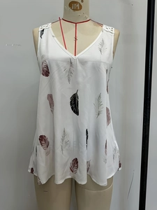 Detail of white V-neck top with colorful feather print and lace crochet shoulders