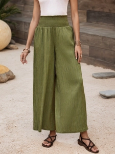 Detail of high waist smocked elastic waistband on olive green wide leg trousers