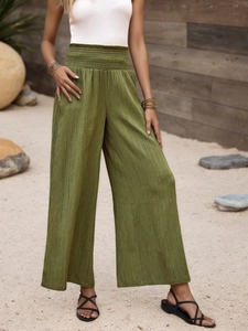 Detail view of olive green wide-leg pants with elastic waist and vertical pleated texture