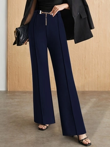 Detail of high-waist wide-leg trousers in dark blue with vertical seams and gold chain