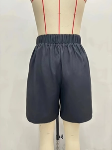 Detail of high waist elastic waistband on black wide-leg dress shorts for women