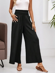 High-waisted black wide-leg trousers with vertical texture and elastic pleated waistband