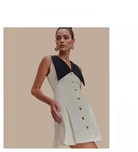 Détail de la robe élégante sans manches avec revers contrasté et boutons dorés devant