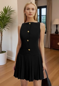 Detail of black sleeveless mini dress with golden buttons and pleated skirt texture