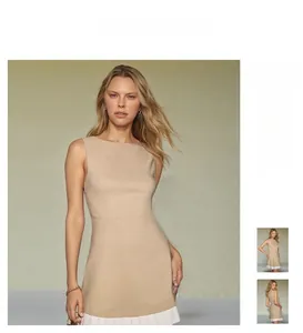 Detail of a beige sleeveless dress featuring white pleated hem stitching and A-line silhouette