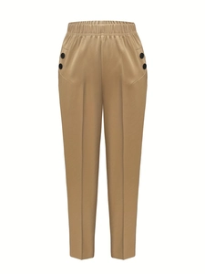 Detailed view of elastic waist and black button accents on khaki plaid trousers