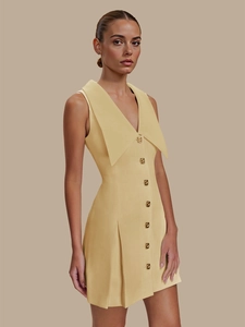Détail de la robe sans manches jaune clair avec boutons dorés texturés et grand col revers