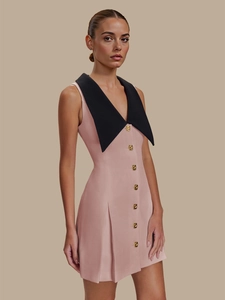 Détail de la robe rose sans manches avec grand col noir contrasté et boutons dorés