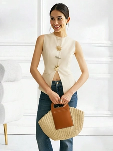 Detail of cream sleeveless vest with decorative sun and feather metal buttons