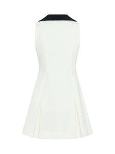 Détail du dos d'une robe blanche sans manches avec col contrasté noir et ourlet à plis