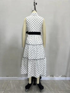 Elegante abito midi bianco a pois senza maniche con cintura nera e gonna a balze