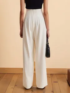 Detail view of white high-waisted wide-leg trousers featuring a discrete back zipper
