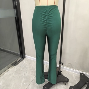 Detalle de pantalones de yoga acampanados verde oscuro con diseño fruncido push-up