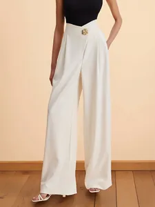 Detail of high-waisted wide-leg trousers in ivory with decorative gold waist button