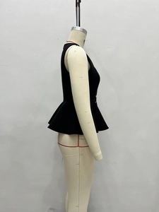 Side view detail of a black sleeveless peplum top with a cinched waist and flared hemline