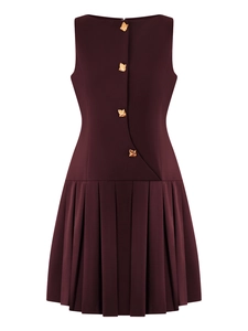 Close-up of sleeveless wine red dress with asymmetric gold buttons and pleated skirt hem