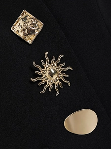 Dreiteiliges Set goldener Metallknöpfe mit Quadrat-, Sonnen- und Oval-Design auf dunklem Stoff