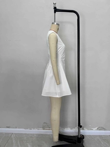 Detailed side view of white sleeveless dress showing ruching and slim fit texture