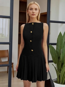 Elegant sleeveless black pleated dress with gold buttons for a minimalist summer look