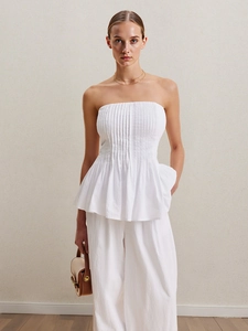 Ensemble élégant blanc avec haut péplum bustier et pantalon large pour un look minimaliste