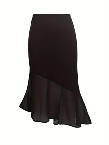 Detail view of high-waist black skirt featuring asymmetric sheer mesh fishtail hemline