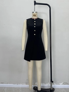 Sleeveless black mini dress with gold buttons and asymmetrical hem on a mannequin
