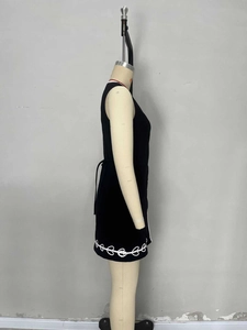 Detail view of black V-neck sleeveless dress with side ties and white floral embroidery