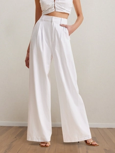 Détail du pantalon blanc taille haute à jambes larges en tissu texturé au style épuré