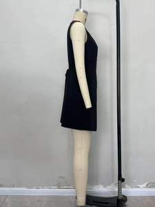 Side profile of a black sleeveless mini dress with tailored waist and structured fabric