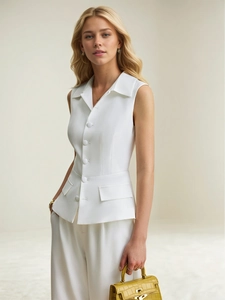 Detail of white sleeveless vest with notched lapels, fabric buttons, and slim fit design