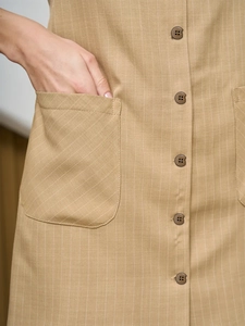 Detail view of khaki striped dress featuring round buttons and functional side pockets