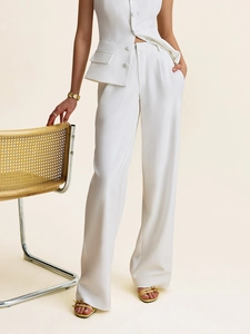Detailed view of white sleeveless vest and high-waisted wide-leg trousers suit set