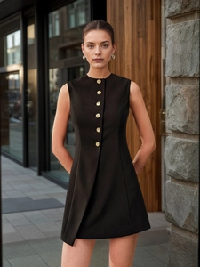 Close-up of golden embossed metal buttons on a black sleeveless A-line dress