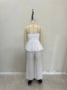 Ensemble blanc deux pièces avec haut caraco plissé et pantalon large sur un mannequin