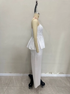 Détail d'un ensemble blanc deux pièces avec haut à basque plissé et pantalon large