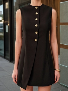 Detail of black sleeveless dress with gold buttons and asymmetric hem structure