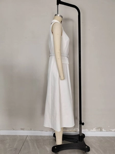 Sleeveless white midi sheath dress with lapel collar and belt shown in profile view