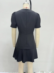 French vintage black mini dress with puff sleeves and pleated skirt from back view